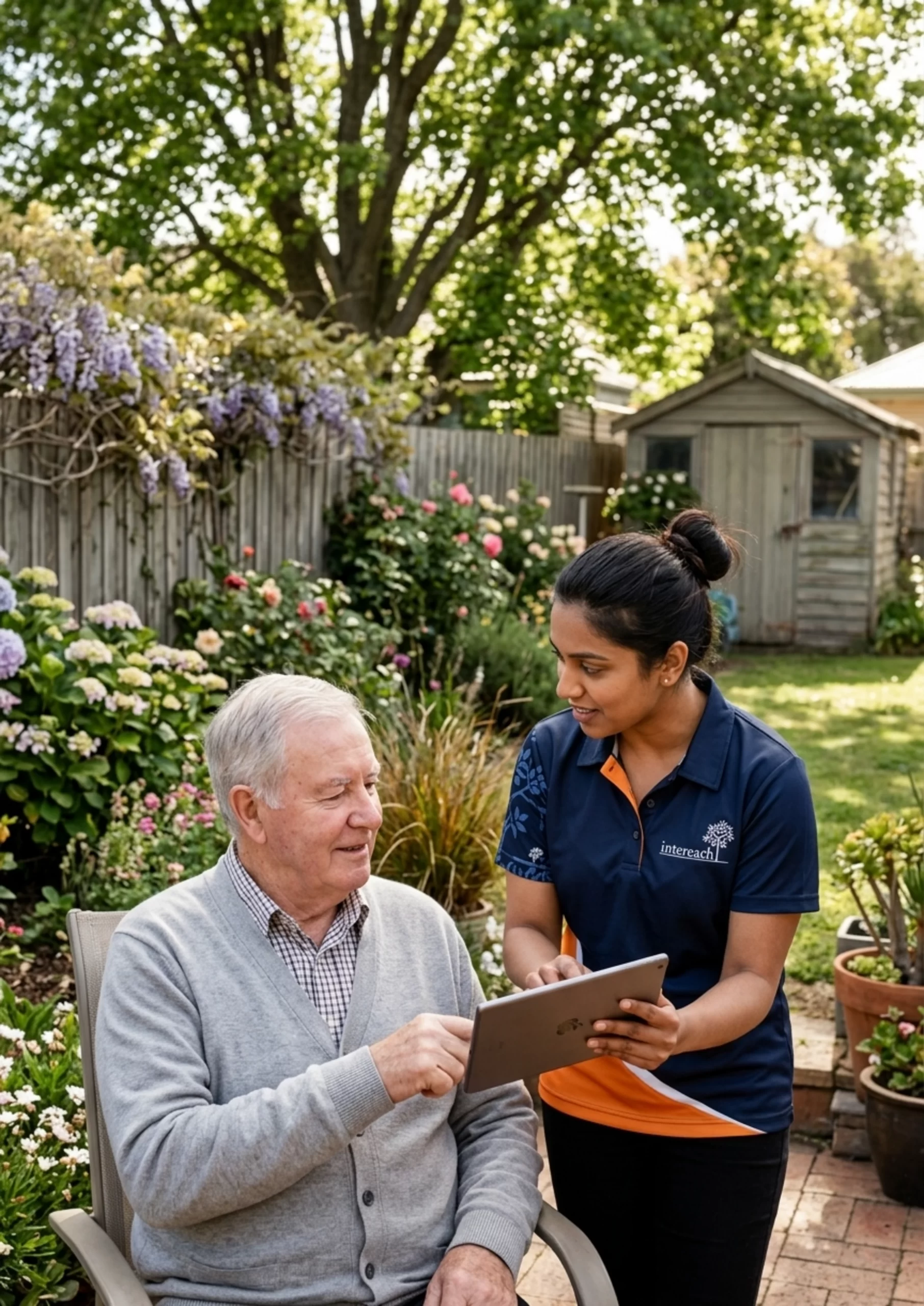 Staff member and older person looking at an ipad